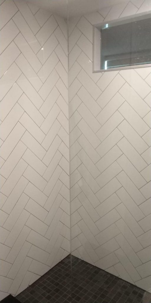 walk in shower with white wall decor tiles - basement design